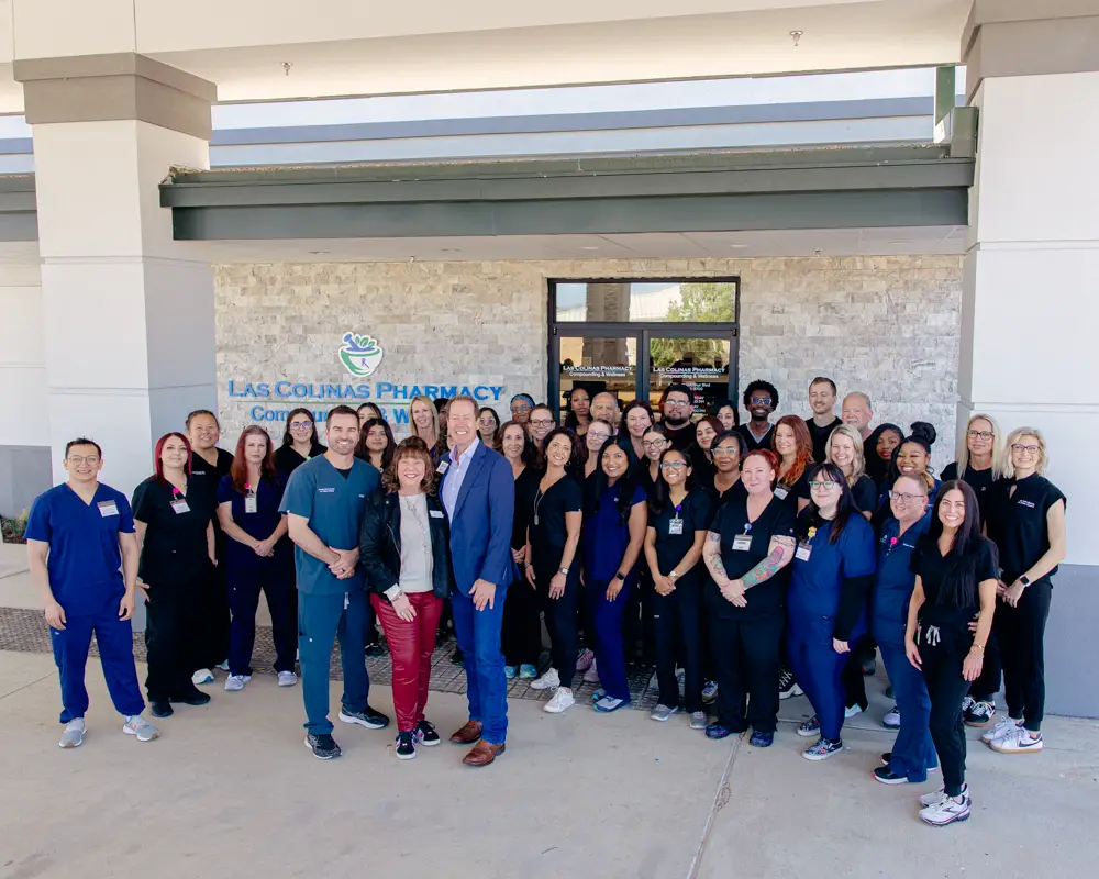 team photo from the exterior of the Las Colinas Pharmacy building