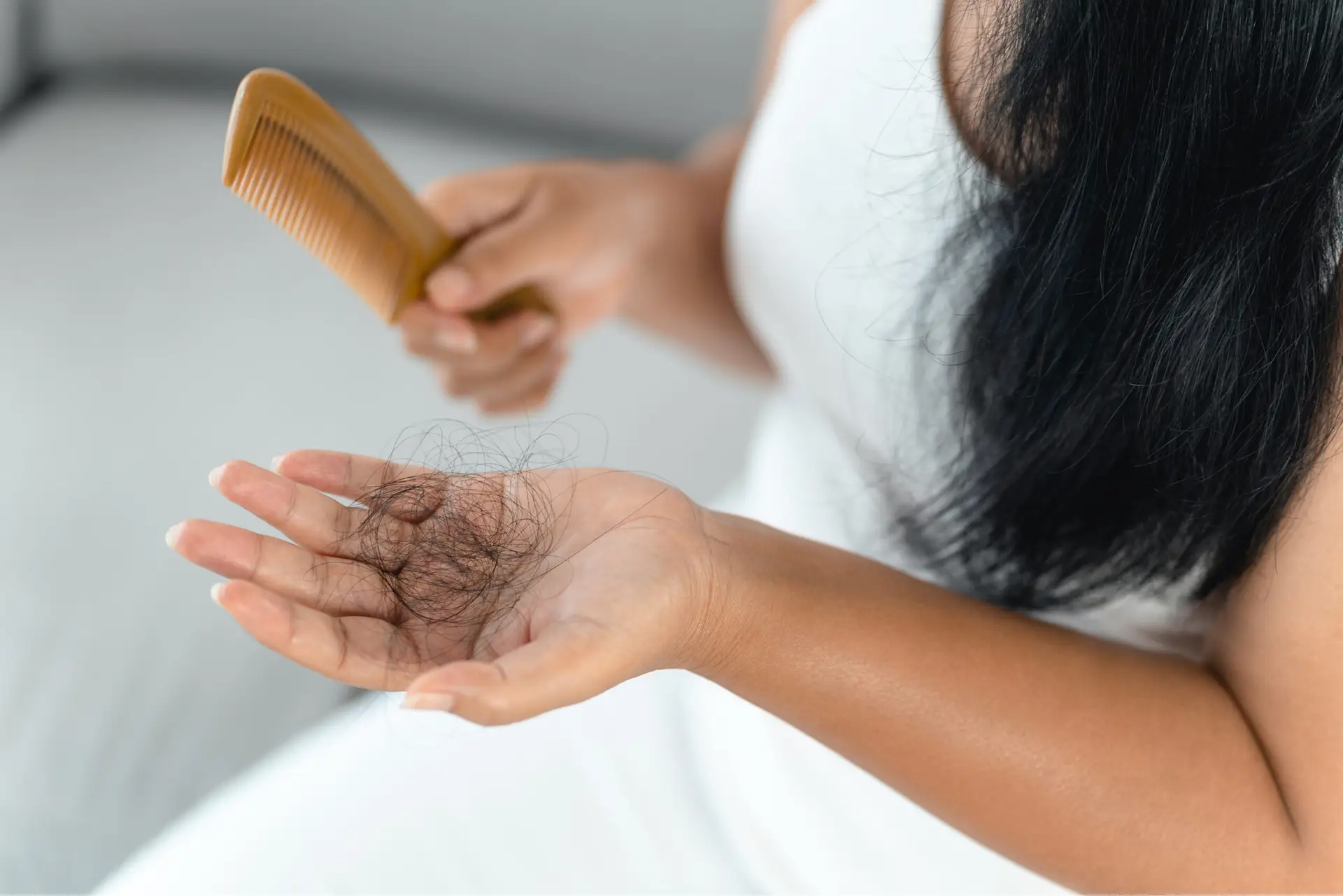 woman holding brushed out hair in hand
