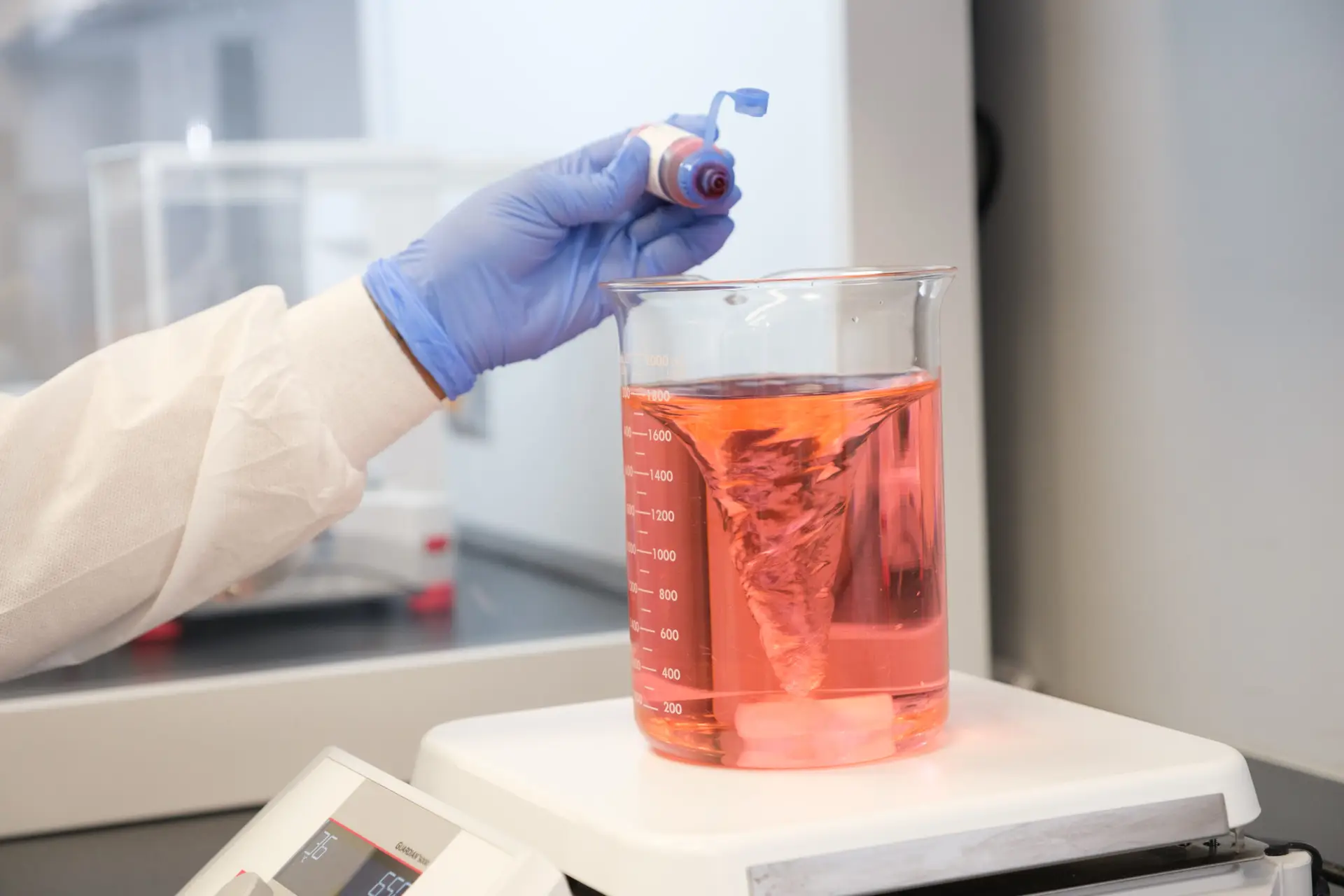 image of compounder adding drops to liquid